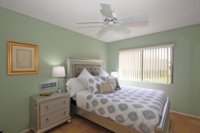 tiled bedroom with a textured ceiling and ceiling fan