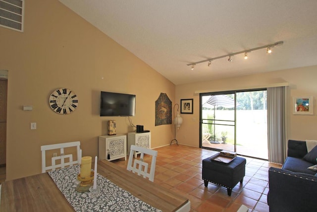 tiled living room featuring vaulted ceiling and rail lighting