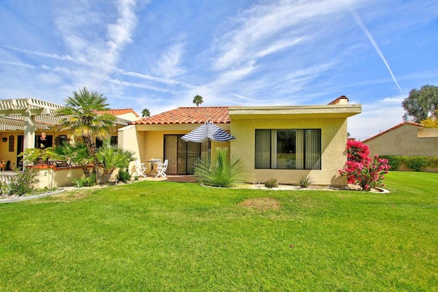 back of property featuring a pergola and a yard