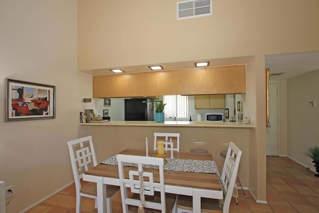 tiled dining area with a high ceiling