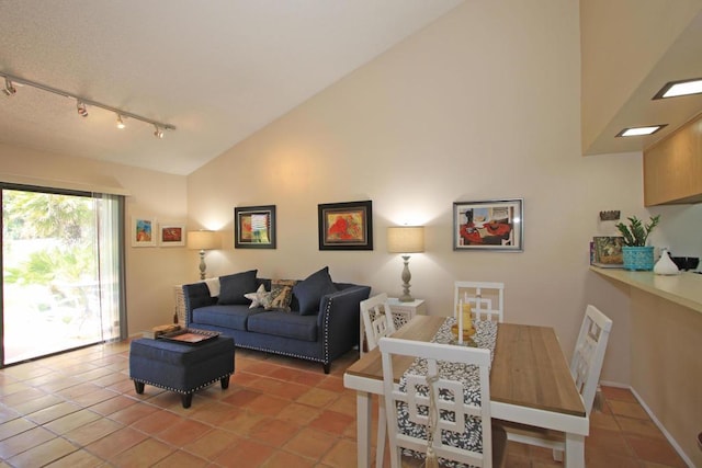 living room with rail lighting, light tile patterned floors, and high vaulted ceiling