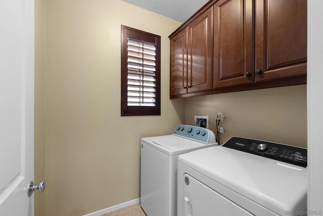 washroom with cabinets and washing machine and clothes dryer