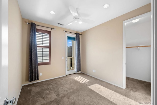 unfurnished bedroom featuring a spacious closet, access to exterior, ceiling fan, light carpet, and a closet