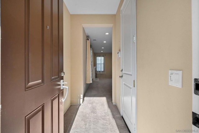 hall with dark colored carpet