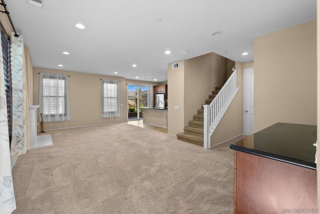 unfurnished living room featuring light colored carpet