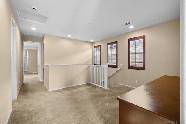 hall featuring light colored carpet