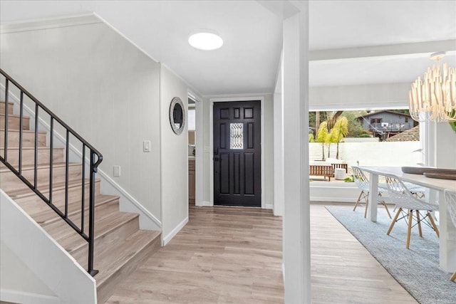 entryway featuring an inviting chandelier and light hardwood / wood-style flooring