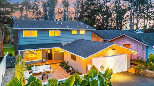 view of front facade featuring a garage, an outdoor hangout area, and a patio area