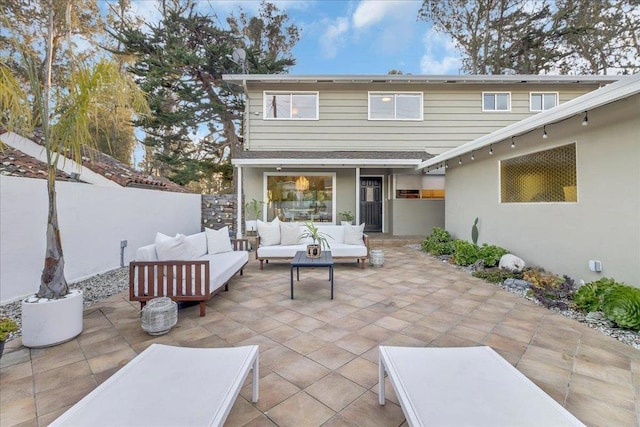 back of property featuring an outdoor living space and a patio