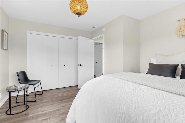 bedroom with light hardwood / wood-style floors and a closet