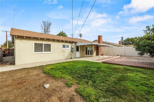 rear view of house with a yard and a patio