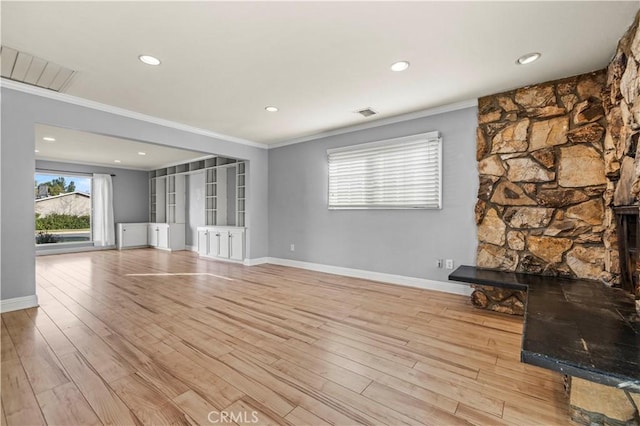 unfurnished living room with ornamental molding and light wood-type flooring