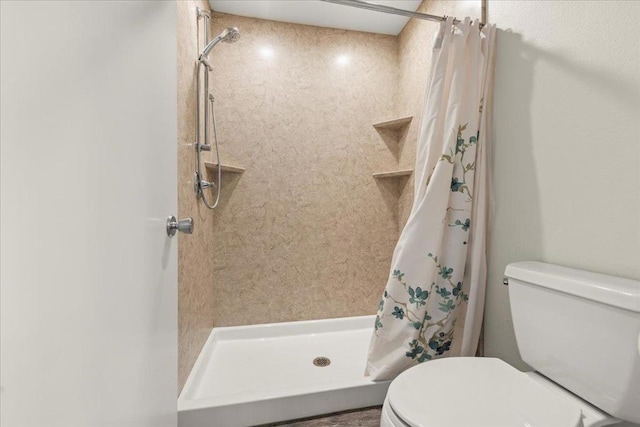 bathroom featuring toilet and a shower with shower curtain