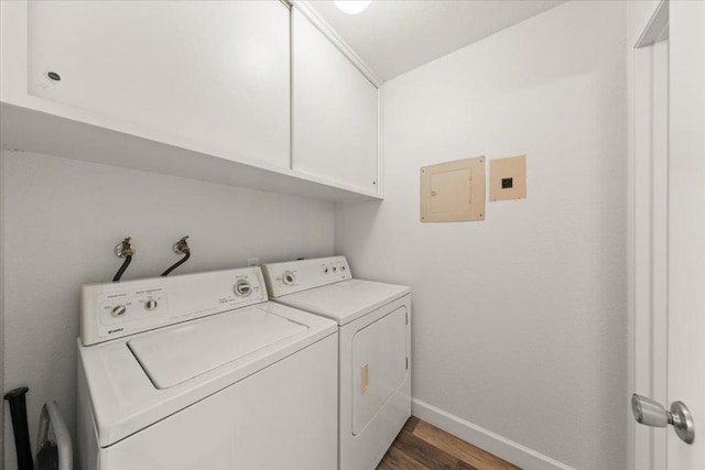 laundry room with dark hardwood / wood-style floors, washing machine and dryer, cabinets, and electric panel