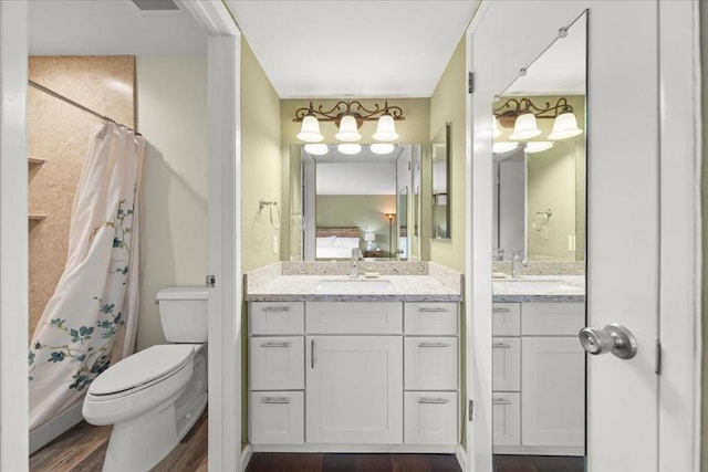 bathroom with walk in shower, vanity, toilet, and hardwood / wood-style floors