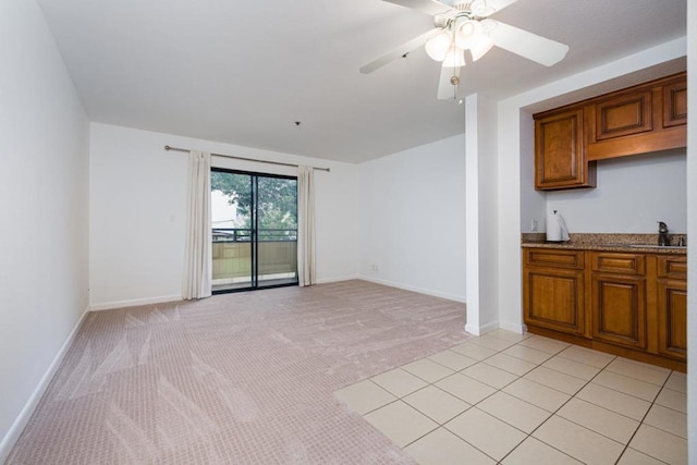 interior space featuring light carpet, sink, and ceiling fan