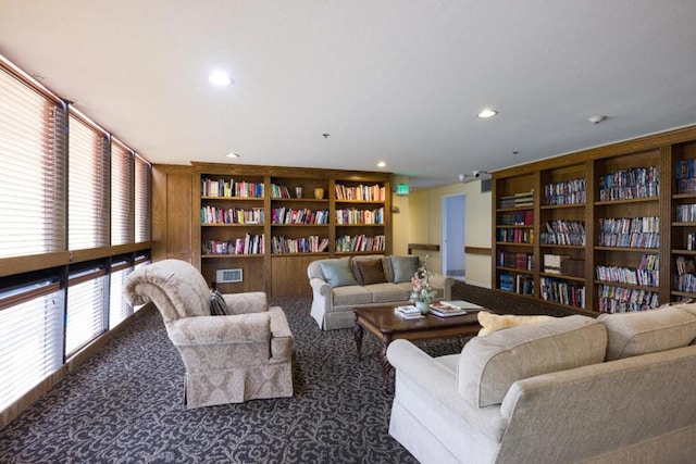 living area with dark carpet and built in shelves