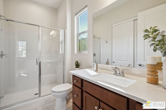 bathroom with a shower with door, vanity, tile patterned flooring, and toilet