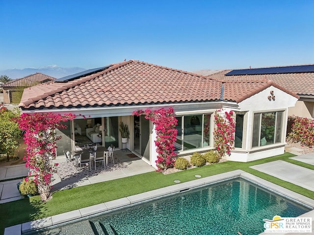 back of house featuring a patio and solar panels