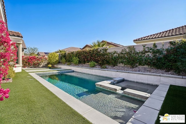 view of swimming pool featuring an in ground hot tub and a lawn