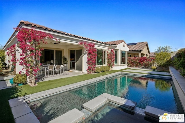 rear view of property featuring a fenced in pool, a patio, and ceiling fan