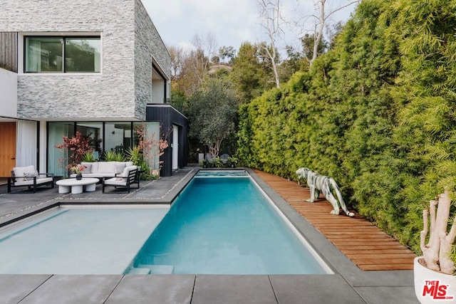 view of swimming pool featuring an outdoor living space and a deck