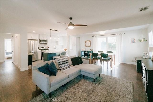 living room featuring ceiling fan and dark hardwood / wood-style flooring