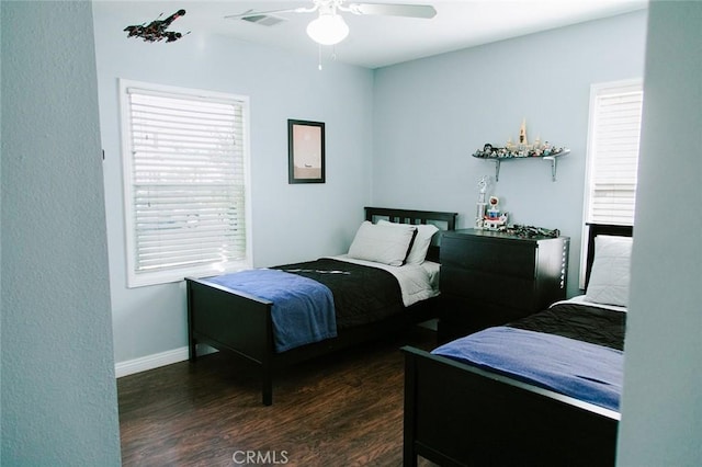 bedroom with dark wood-type flooring, ceiling fan, and multiple windows