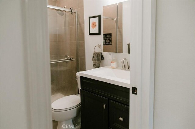 bathroom featuring vanity, toilet, and an enclosed shower