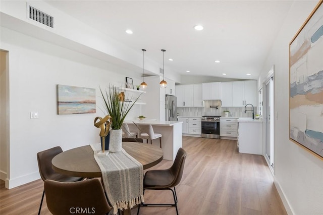 dining area with sink and light hardwood / wood-style flooring