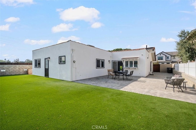 rear view of house featuring a patio and a lawn