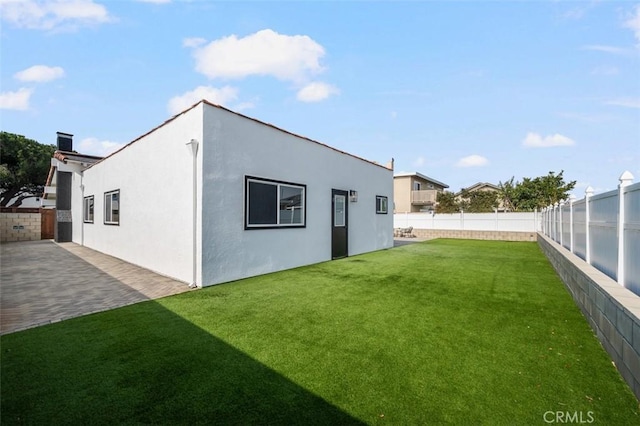 rear view of property featuring a patio and a yard