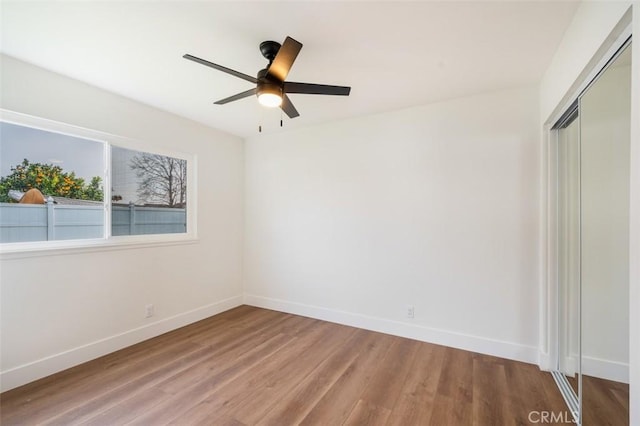 unfurnished bedroom featuring hardwood / wood-style floors, a closet, and ceiling fan