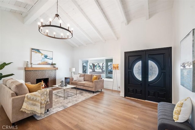 living room with an inviting chandelier, high vaulted ceiling, wooden ceiling, beamed ceiling, and light wood-type flooring