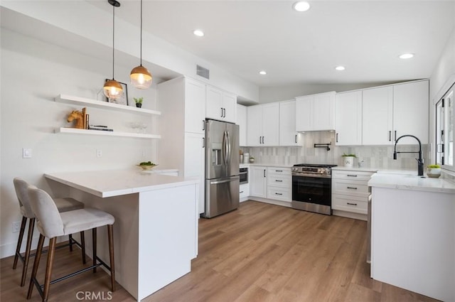 kitchen featuring white cabinetry, a breakfast bar, appliances with stainless steel finishes, and kitchen peninsula