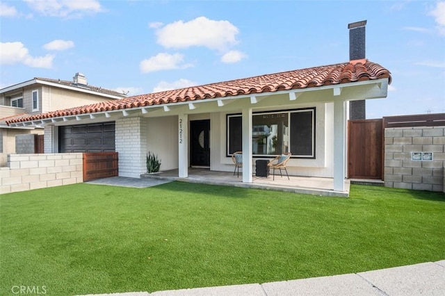 rear view of property featuring a lawn and a patio