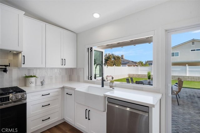 kitchen featuring white cabinetry, backsplash, stainless steel appliances, and sink