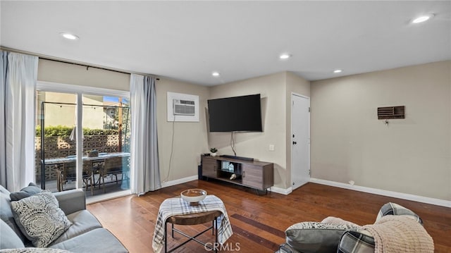 living room with dark hardwood / wood-style flooring and a wall mounted AC