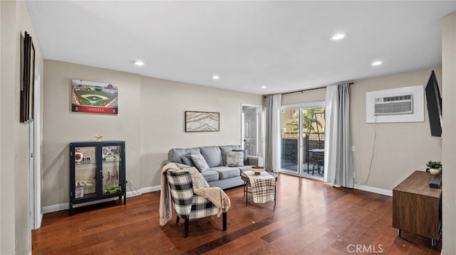 living room featuring dark hardwood / wood-style flooring and an AC wall unit