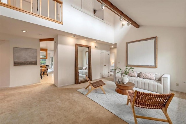 living room featuring high vaulted ceiling, light colored carpet, rail lighting, and beamed ceiling