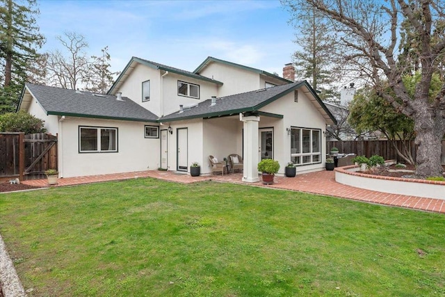 rear view of house with a yard and a patio area