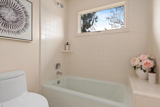 bathroom with tiled shower / bath and toilet