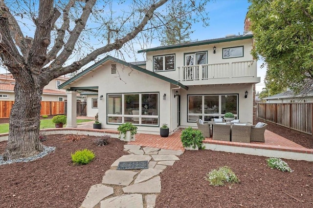 back of house with an outdoor living space, a patio, and a balcony