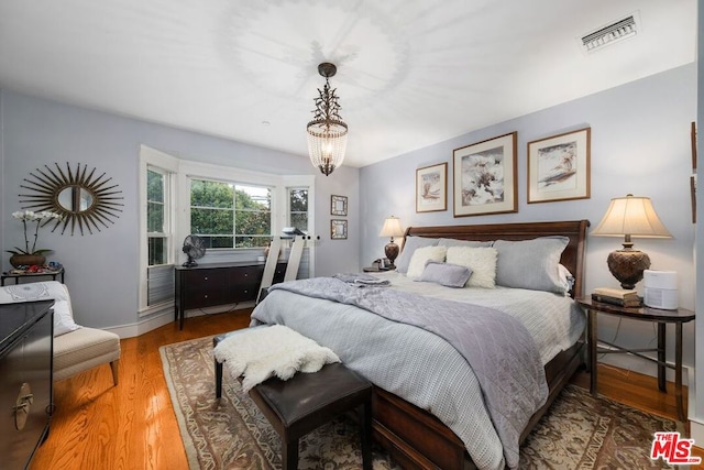 bedroom featuring hardwood / wood-style flooring and a notable chandelier