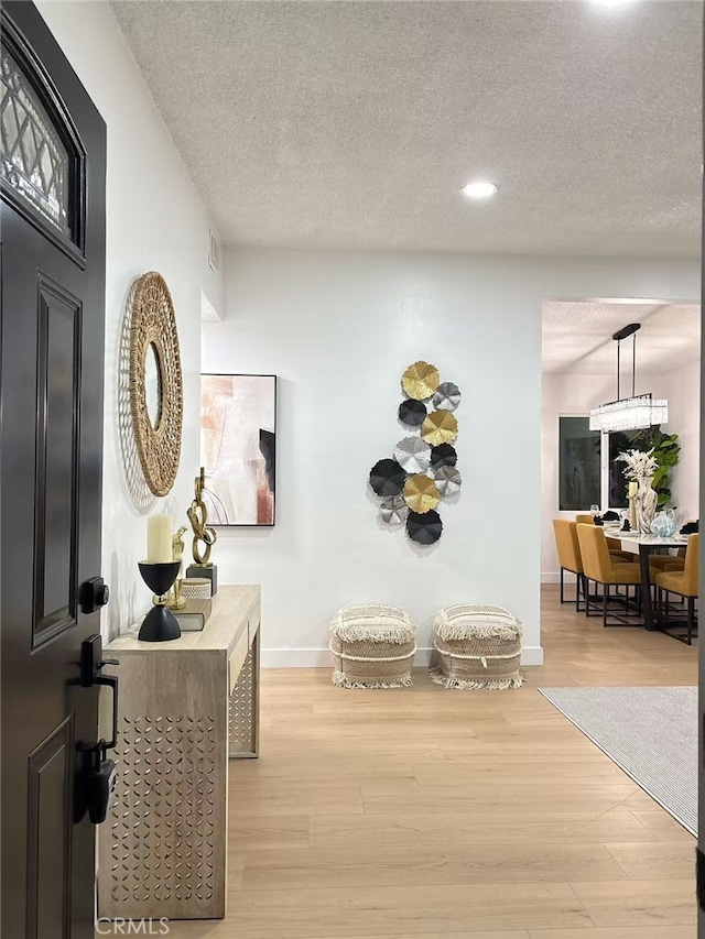 hallway featuring a textured ceiling and light wood-type flooring