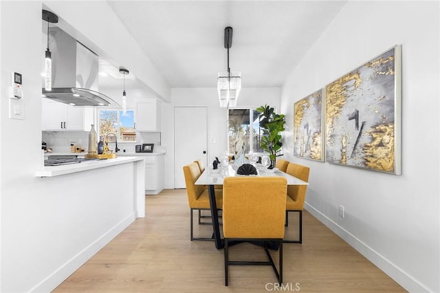 dining room featuring sink and light hardwood / wood-style flooring