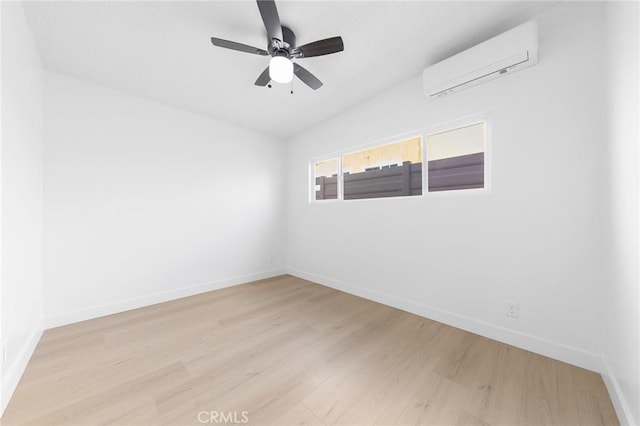 spare room with ceiling fan, a wall mounted air conditioner, and light hardwood / wood-style flooring