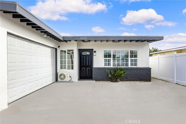 entrance to property with a garage and ac unit