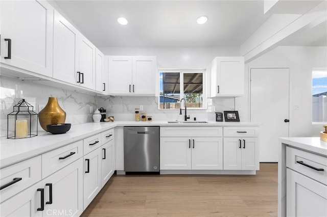 kitchen with dishwasher, sink, white cabinets, and light hardwood / wood-style flooring