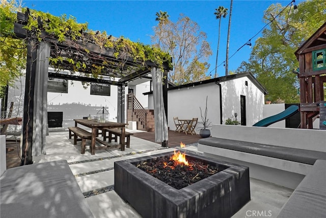 view of patio with an outbuilding and a fire pit